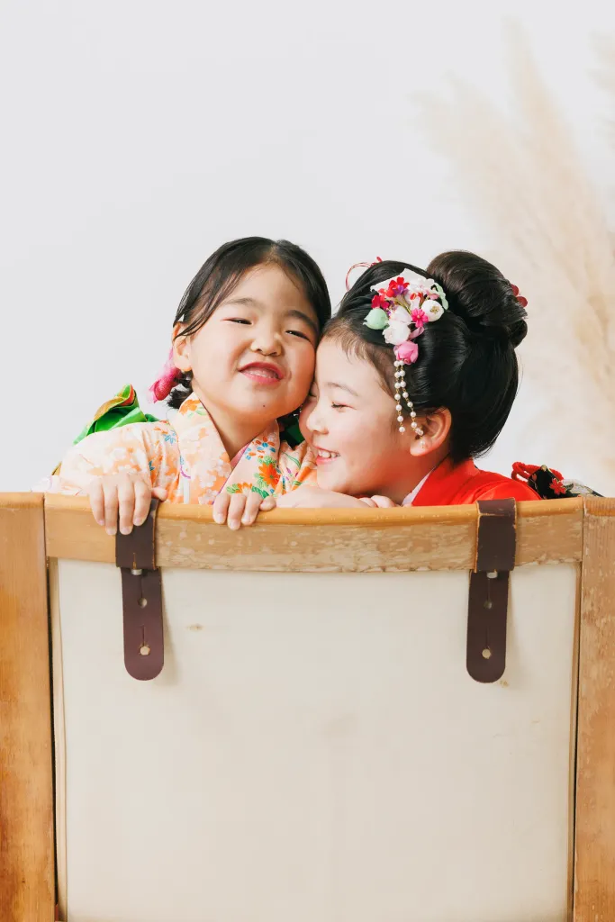 スタジオで頬を寄せ合う晴れ着姿の女の子ふたり